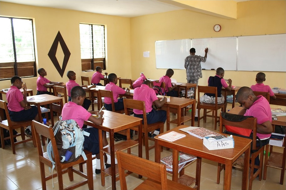 Classroom. 12 Students in chairs. 1 empty chair.