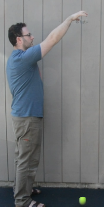 A man dropping a ball.