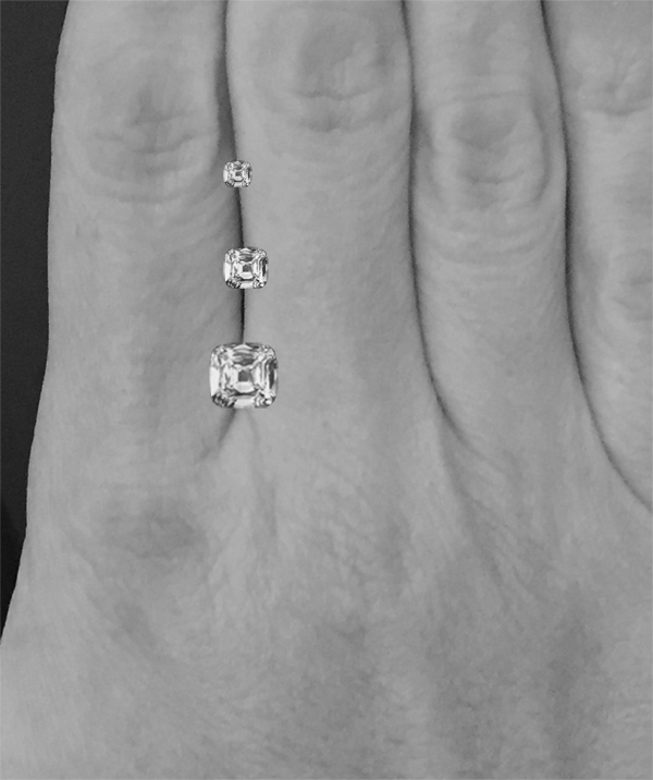 Image of three different sized diamonds on a hand.