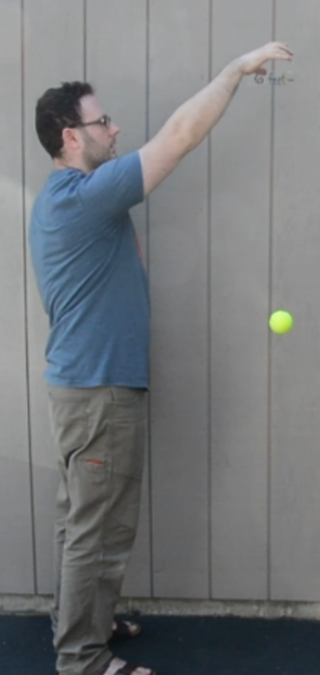 A man dropping a ball.