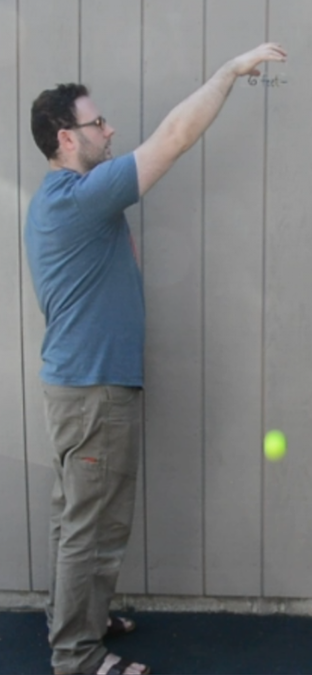 A man dropping a ball.