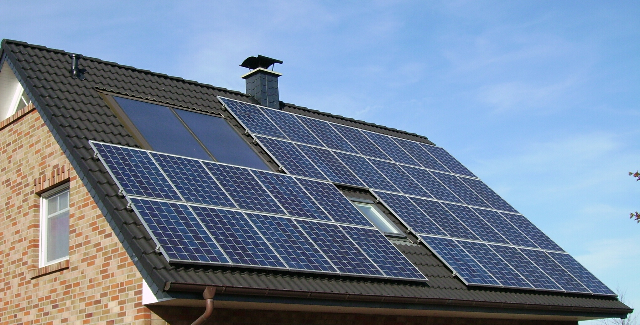 An image of the side of the roof of a house. The roof has solar panels on it.
