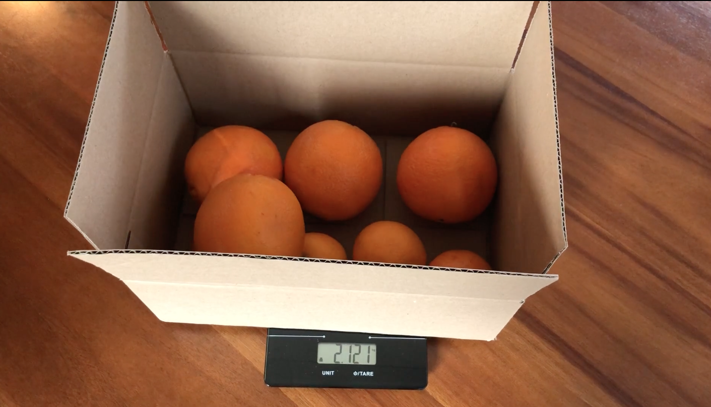 Video still of oranges being weighed