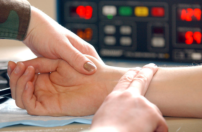 woman taking man's radial pulse