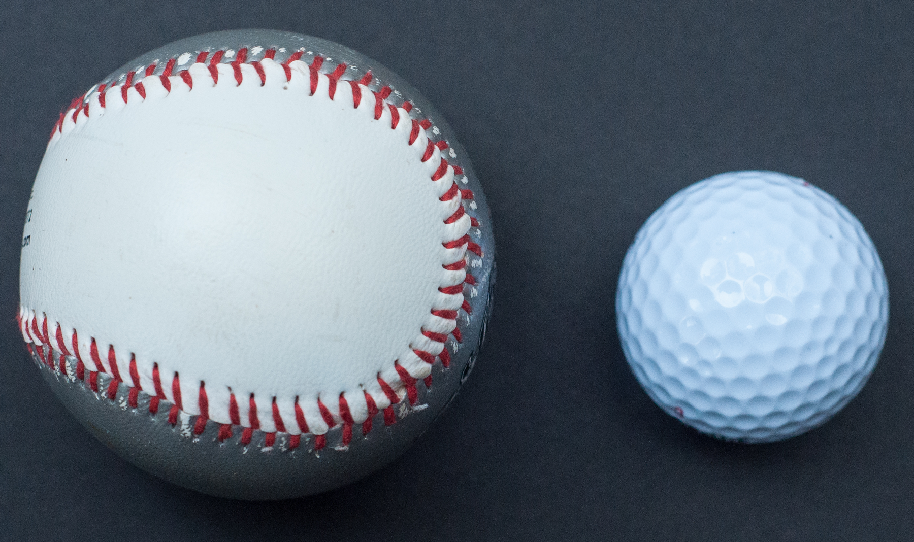 Photo of a baseball and a golf ball.