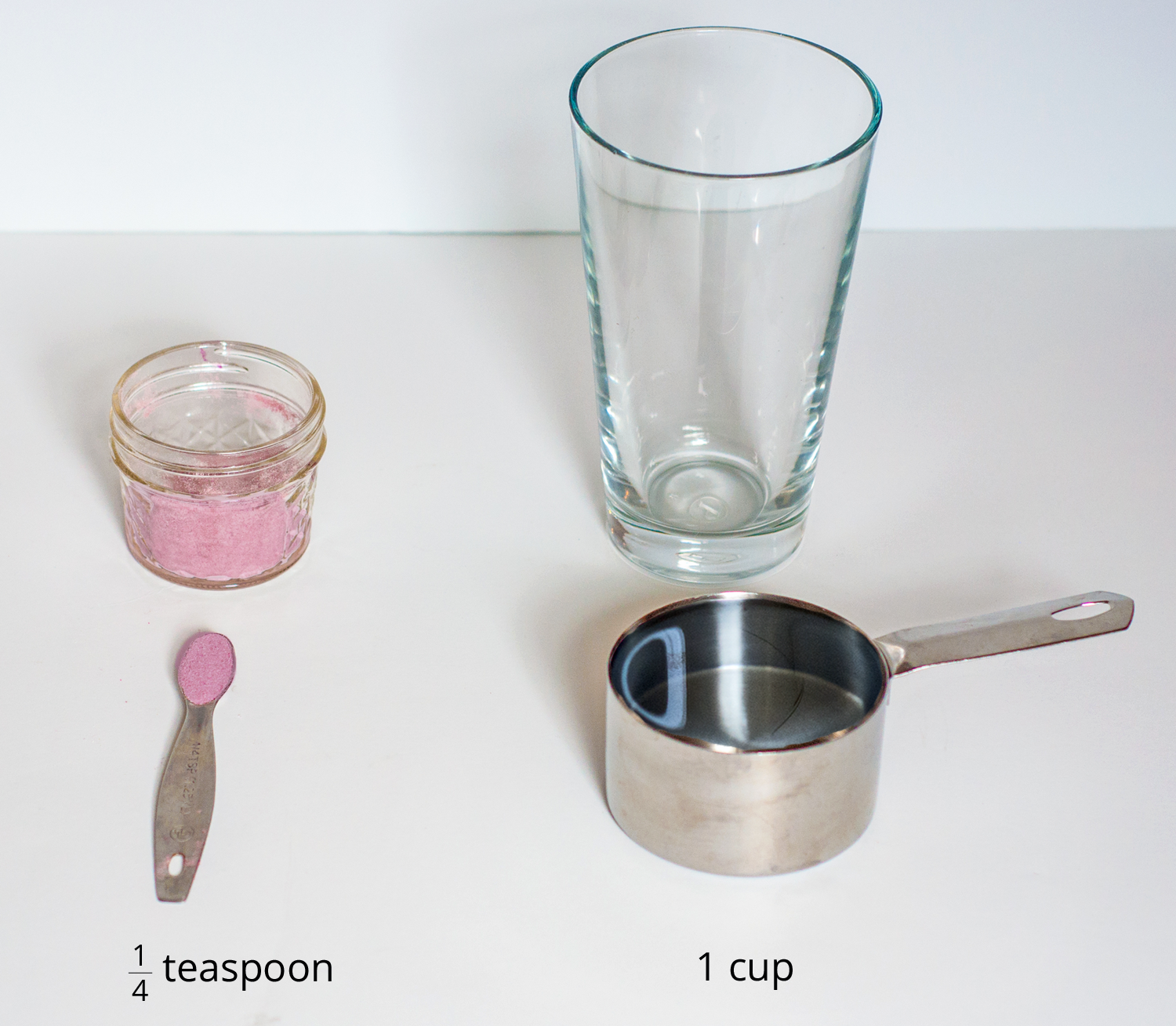 A picture of a glass, drink mixture in a container, a quarter teaspoon of drink mix, and a measuring cup.