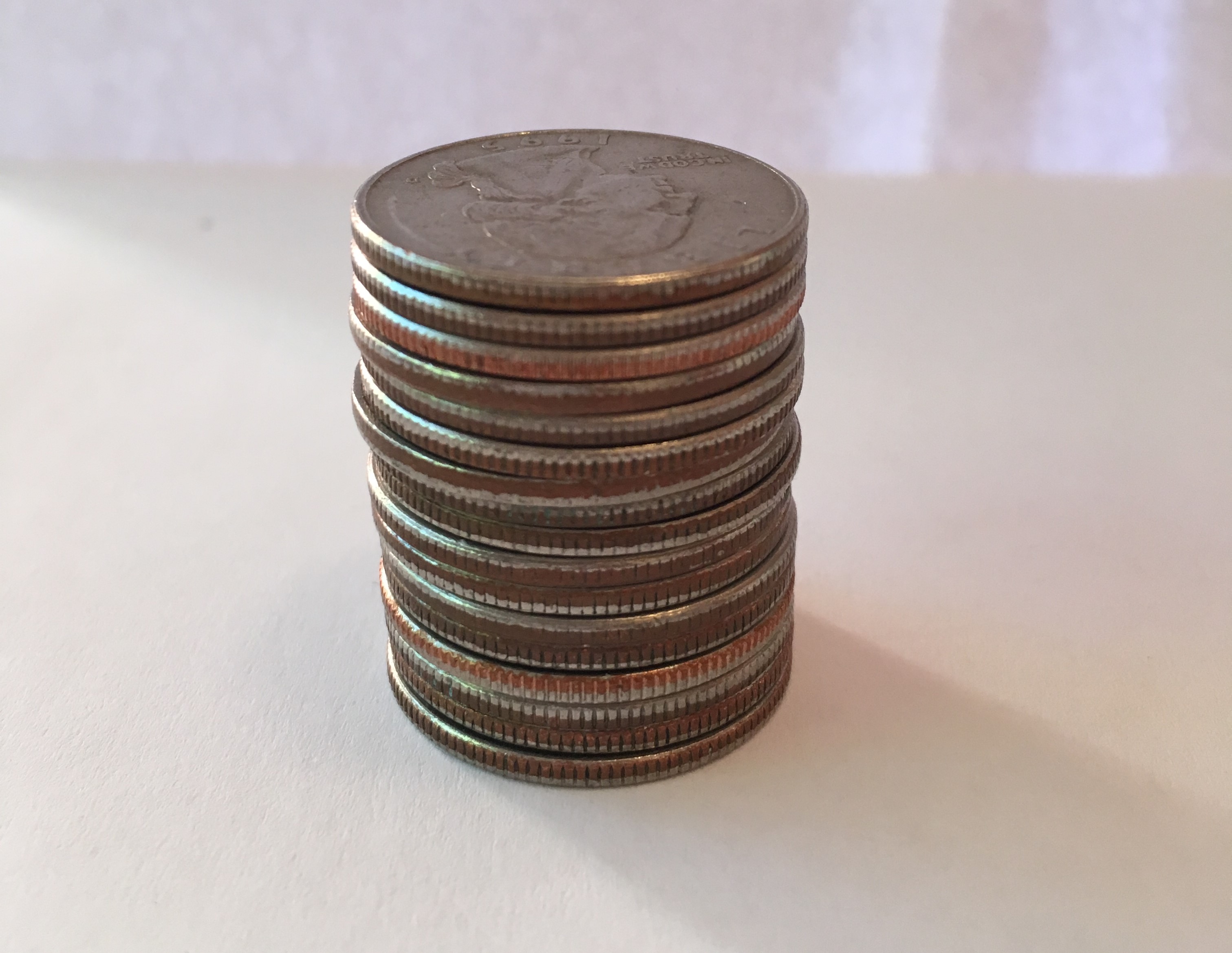 A photo of a stack of coins, quarters.