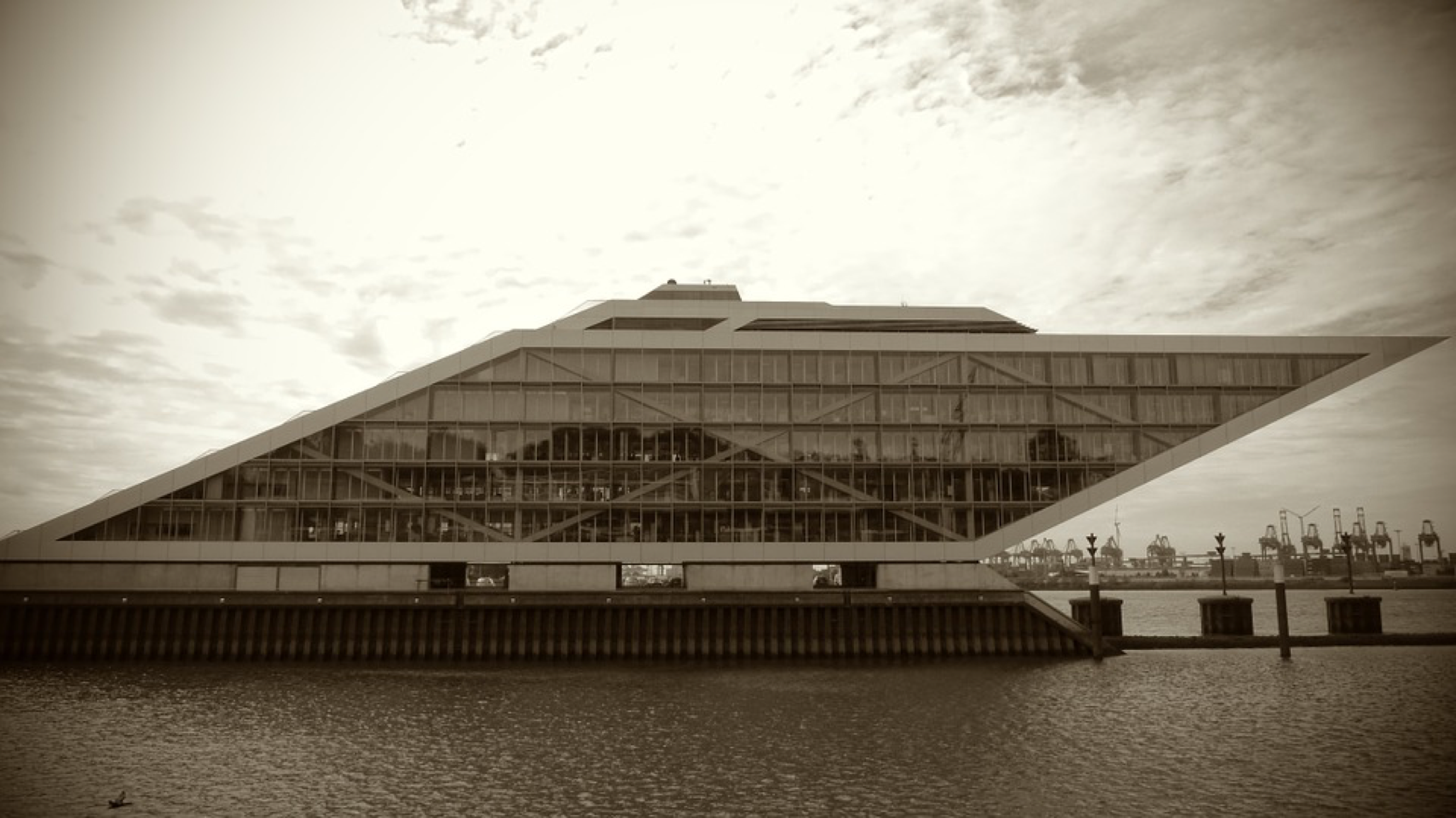 A photograph of the Dockland Building in Hamburg, Germany. The building is shaped like a parallelogram.