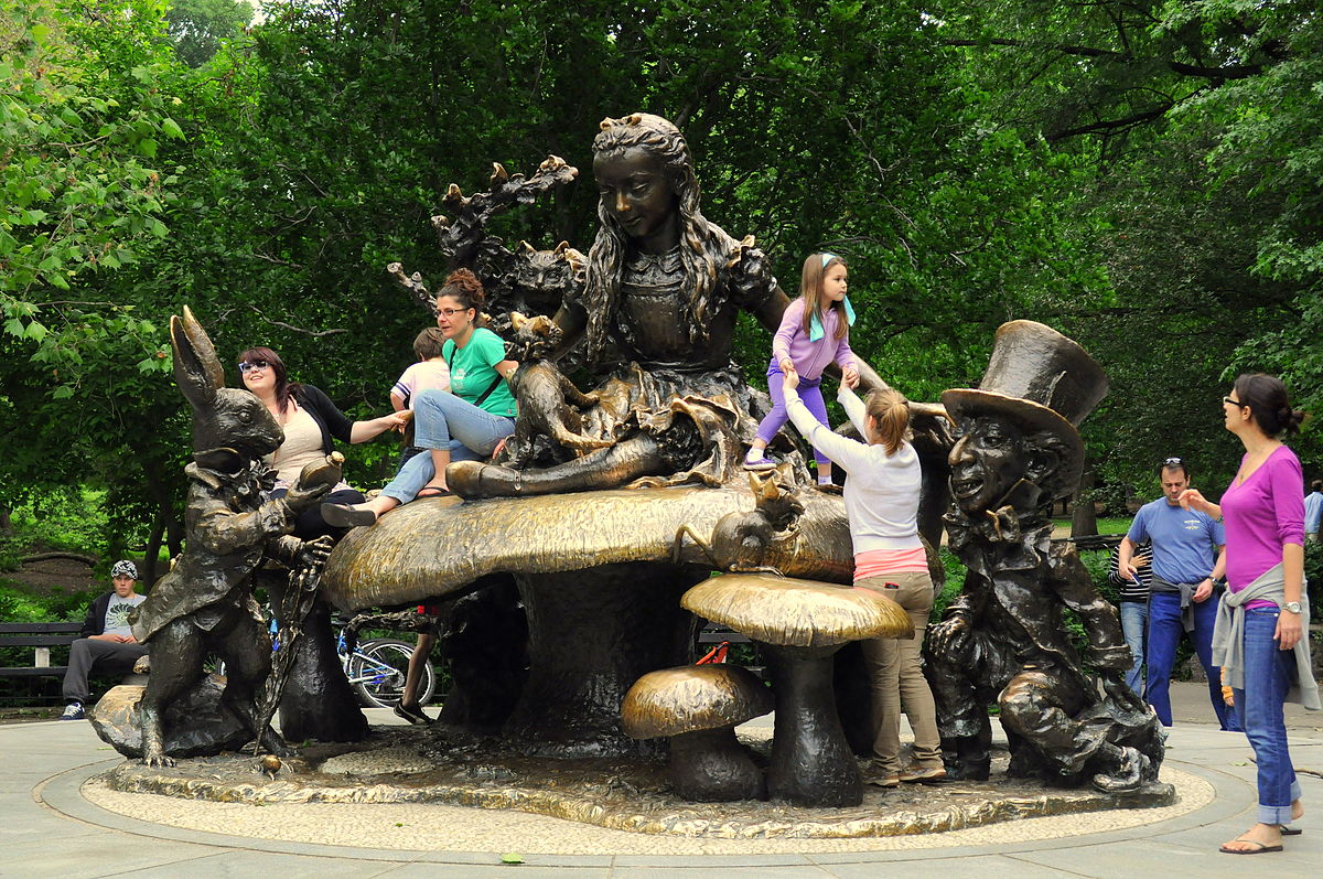 People playing on a statue in a park.