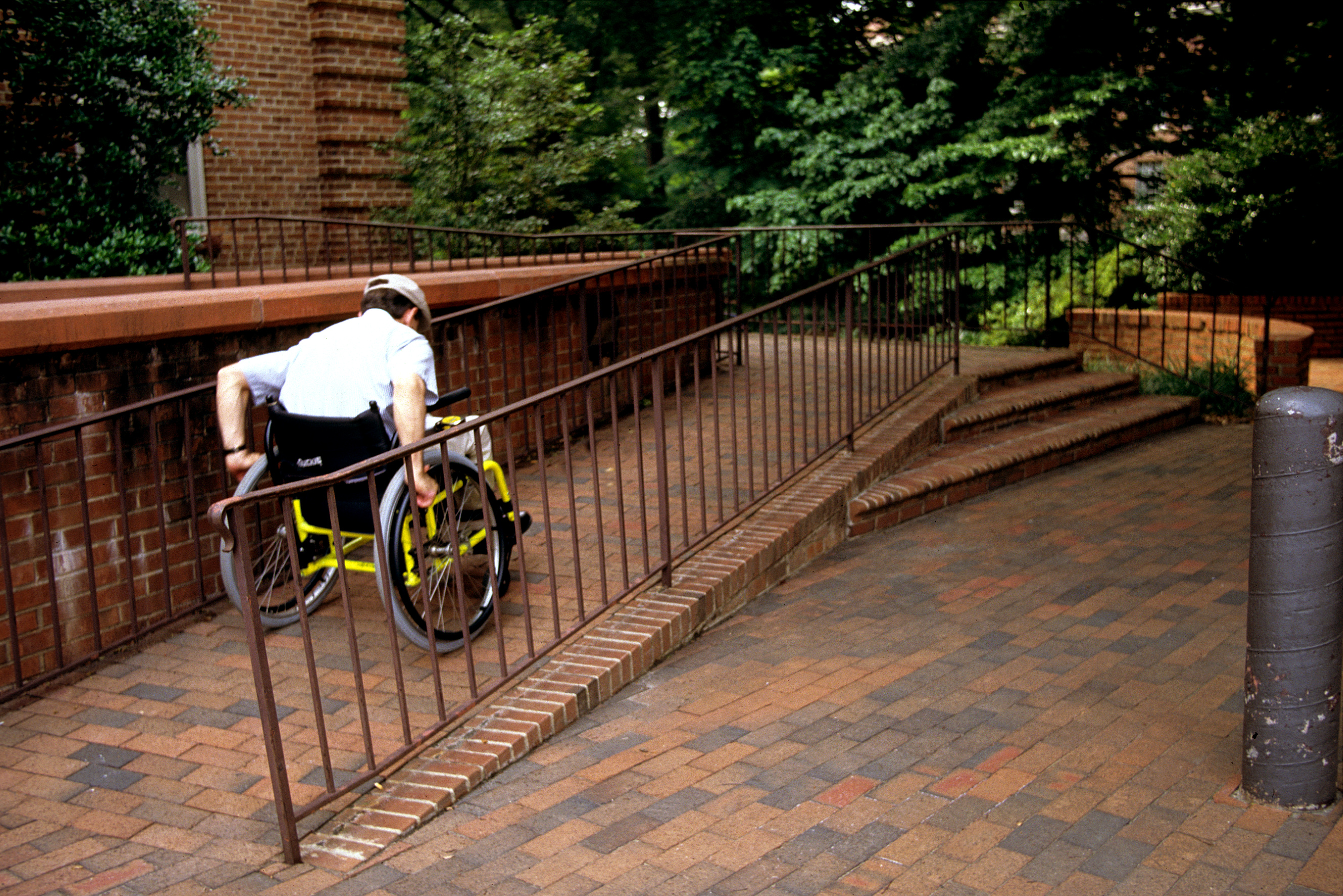 Photo of a man in a wheelchair going up a ramp
