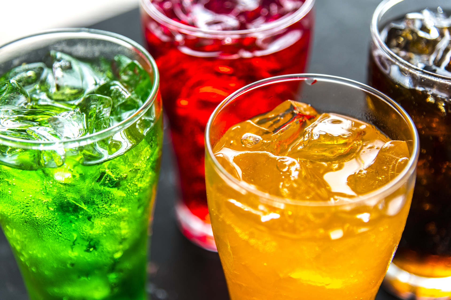 a photo of four glasses of colorful, fizzy beverages