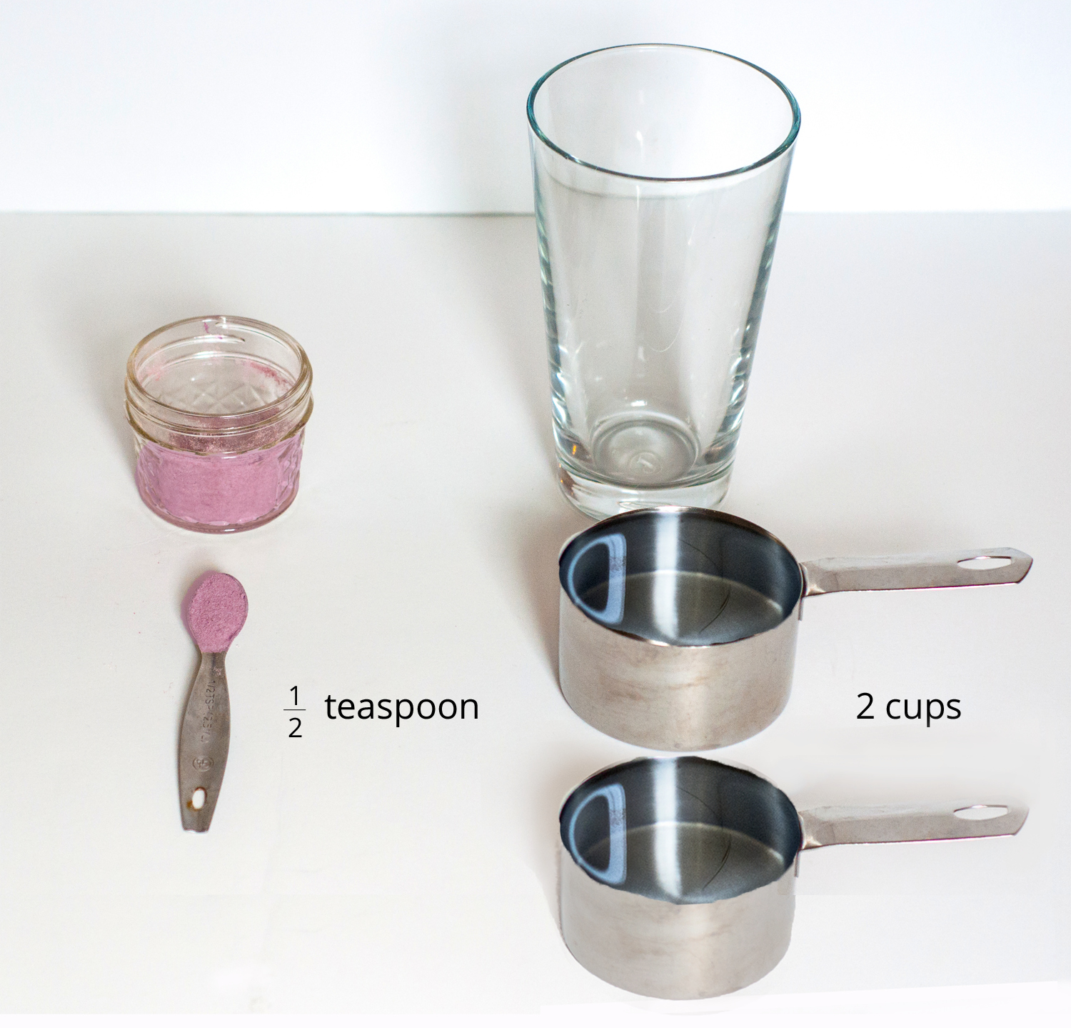 A picture of a glass, drink mixture in a container, one half of a teaspoon of drink mix, and 2 measuring cups.