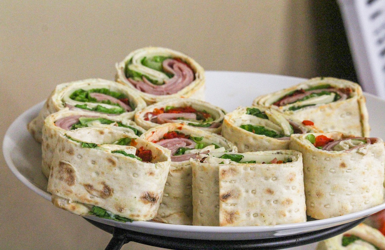 Many rolled-up sandwiches on a plate.