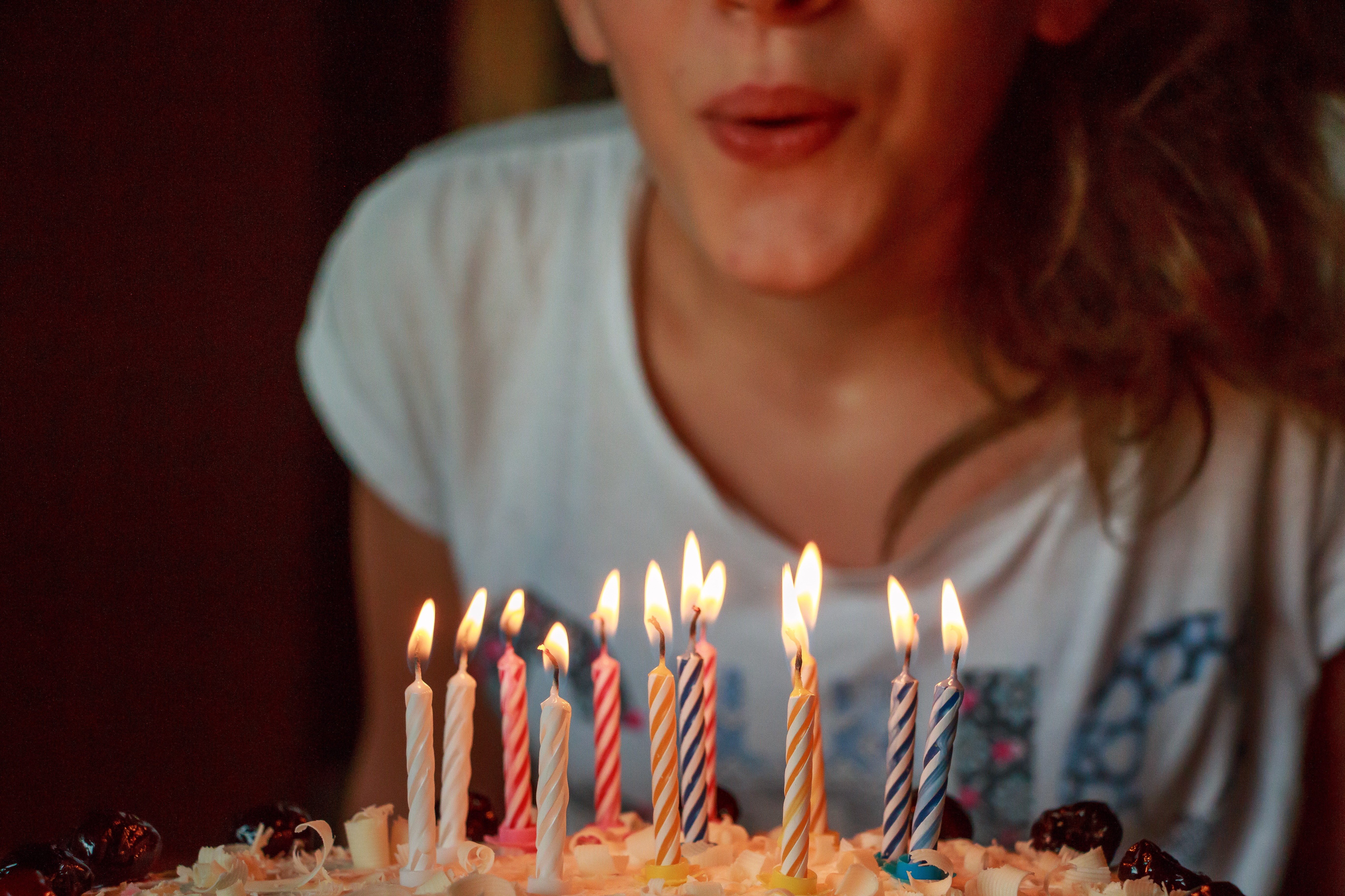 Girl blowing out candles on a cake.