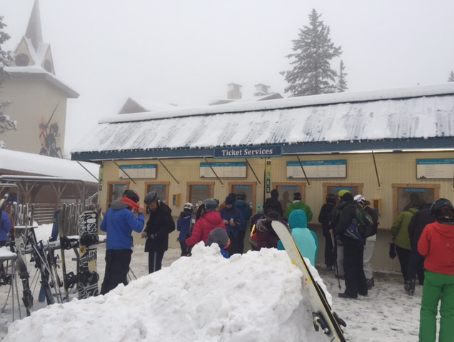 A picture of people waiting to buy tickets to ski or snowboard.