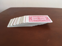 A photo of a whole deck of playing cards, stacked, each one shifted slightly to the right of the one below.
