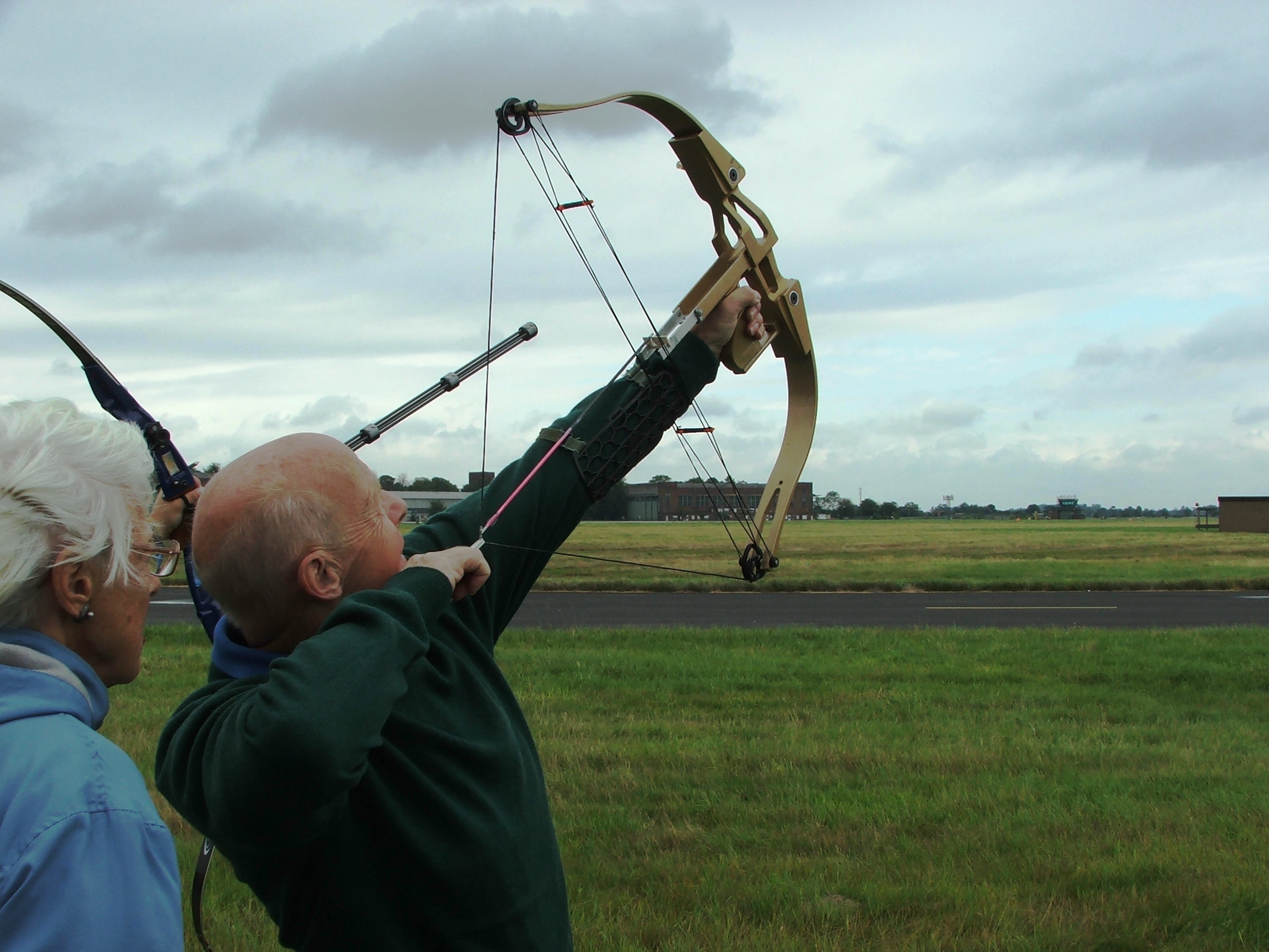 man shooting bow and arrow into the sky.