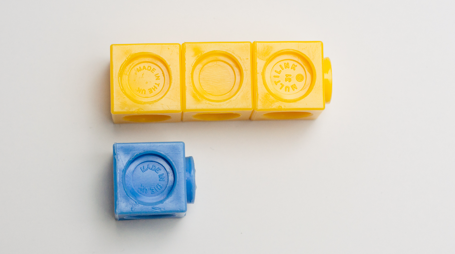Picture. Interlocking cubes. 3 yellow. 1 blue.